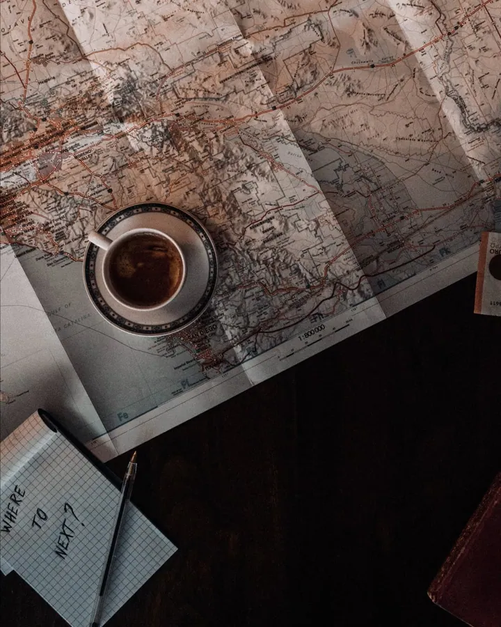 A cup of coffee on a tabletop printed with a world map in the cafe film.